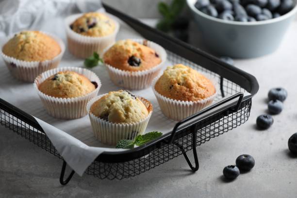 istock Delicious sweet muffins with blueberries and mint on grey table 1865493843