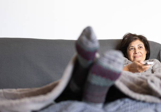 istock mature woman zapping with the remote control on the sofa 1865497107