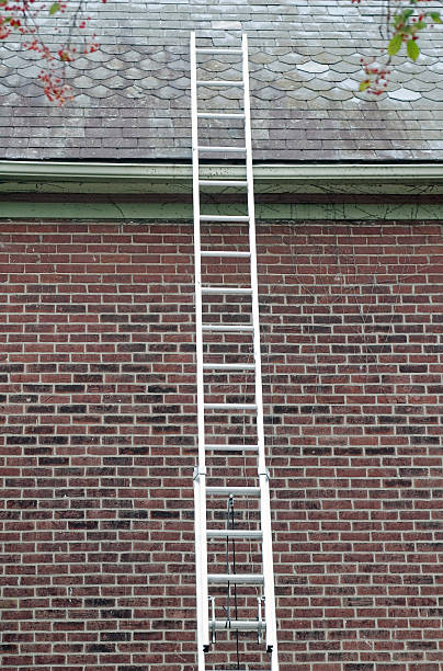 Ladder Against Slate Roof stock photo