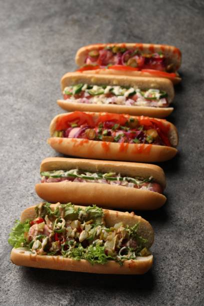 istock Delicious hot dogs with different toppings on grey table 1865523060