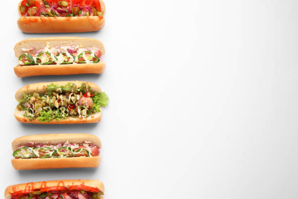istock Delicious hot dogs with different toppings on white background, flat lay. Space for text 1865523061