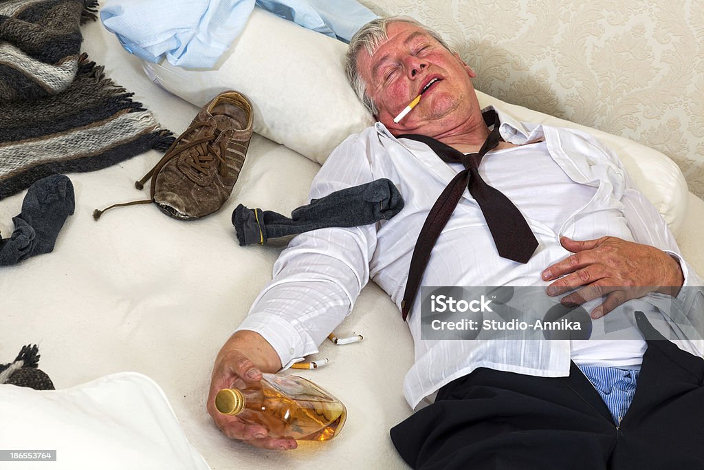 Drinking in bed Old drunk lying in a messy bed Drunk Stock Photo