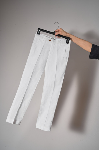 White classic pants on hanger mockup. School uniform, branding mock up. Studio shot, close up, grey background