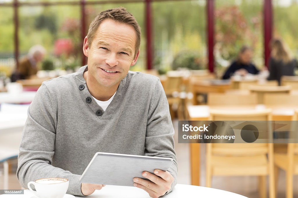 Homme à l'aide de tablette numérique au café - Photo de Activité de loisirs libre de droits
