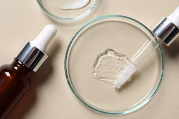 istock Bottle of cosmetic serum and petri dishes with samples on beige background, flat lay 1865559639