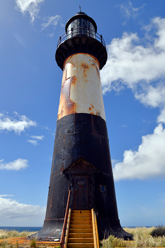 Cape Pembroke / Cabo San Felipe, East Falkland, Falkland Islands: Cape Pembroke lighthouse - metal tower completed in 1907 by Trinity House, using a light mounted on a clockwork stand, painted black with a broad white band - Cape Pembroke is the most easterly point of the Falkland Islands.