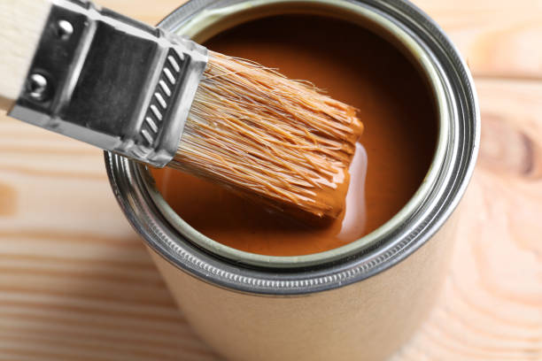 istock Dipping brush into can with wood stain on wooden surface, closeup 1865574100