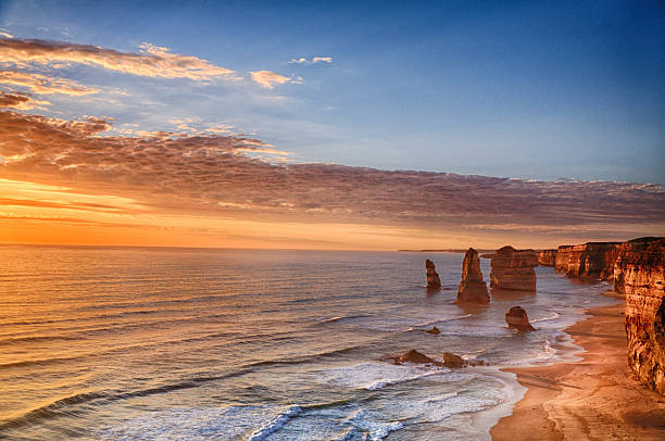 Twelve Apostles, Port Campbell National Park at sunset - Victoria, Australia. Sunlight hitting the rocks and sand creating a very sureal look. 