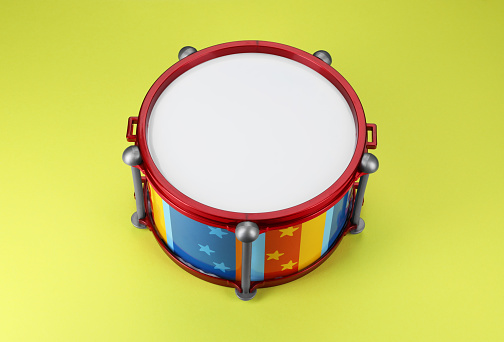 Colorful drum on light green background. Percussion musical instrument
