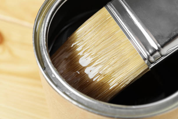 istock Dipping brush into can with varnish on table, closeup 1865577225