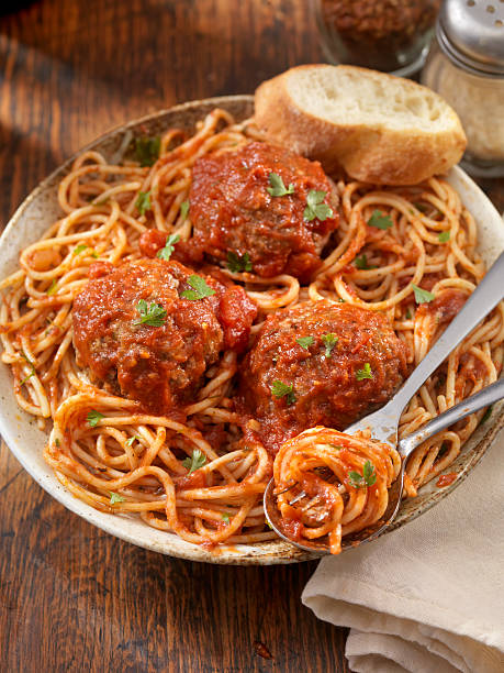 Spaghetti with Large Meatballs Spaghetti with Large Meatballs in a Tomato Basil Sauce with fresh Bread -Photographed on Hasselblad H3-22mb Camera big plate of food stock pictures, royalty-free photos & images