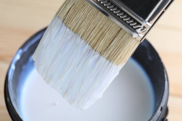 istock Dipping brush into can with varnish on table, closeup 1865578265