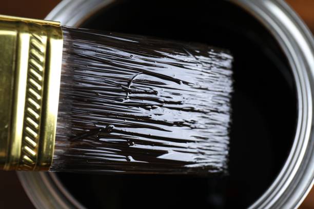 istock Dipping brush into can with wood stain, closeup 1865580357