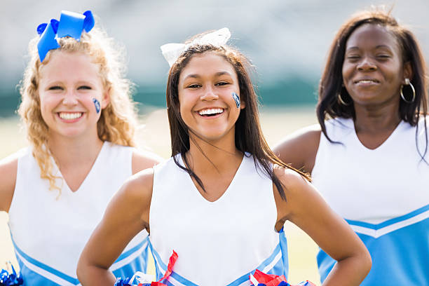 Cute group of high school cheerleaders at football game Cute group of high school cheerleaders at football game cheerleader photos stock pictures, royalty-free photos & images