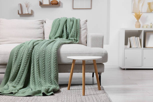 istock Knitted plaid on comfortable sofa in living room. Space for text 1865601447
