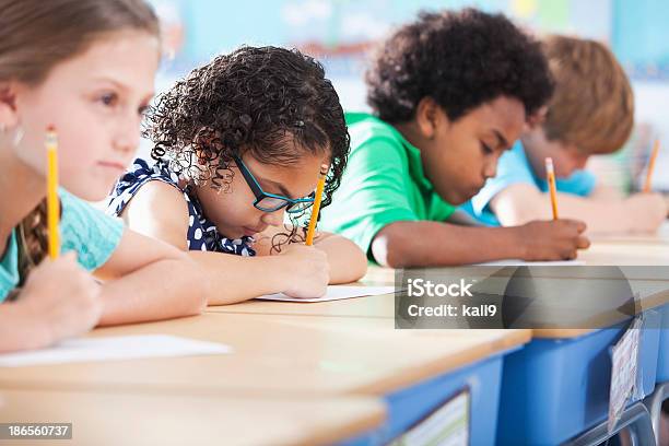 Foto de Crianças Na Escola Primária De Classe Escrevendo e mais fotos de stock de Exame - Exame, Criança, Escrever