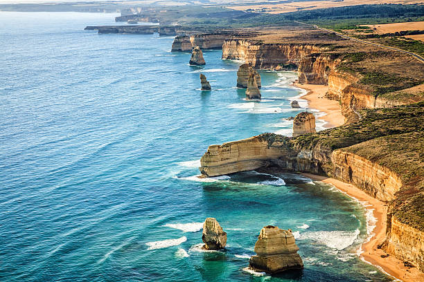 Aerial view Twelve Apostles, Port Campbell National Park at sunset Aerial view of theTwelve Apostles, Port Campbell National Park at sunset - Victoria, Australia. Shot from a helicopter.  twelve apostles sea rocks victoria australia stock pictures, royalty-free photos & images