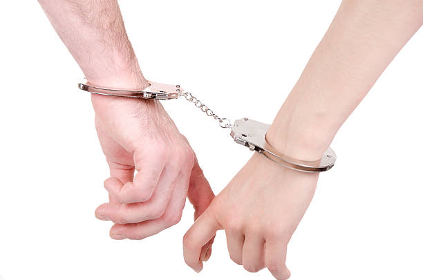 istock Man and woman hands in handcuffs. 186563368