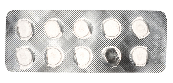 Empty blister pack of round pills on a white isolated background, top view