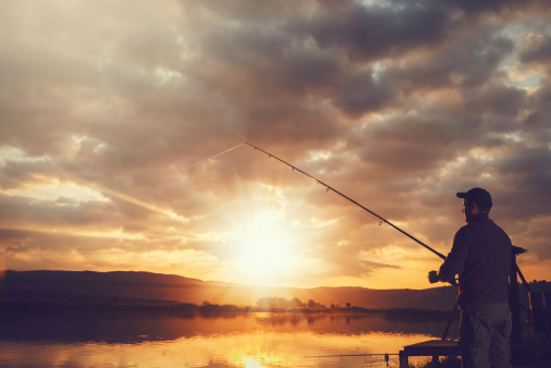 young man fishing at sunrise.