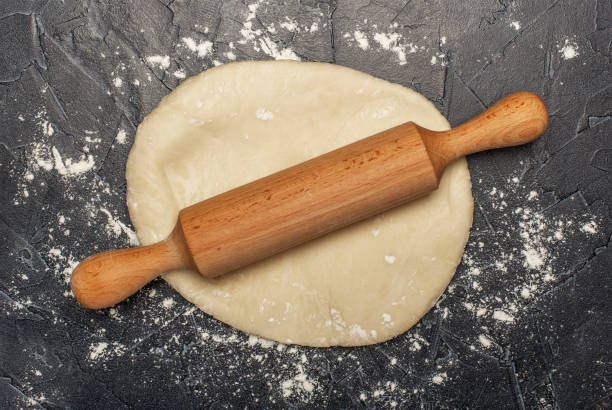 istock ball of fresh raw dough, flour and rolling pin top view 1865652934