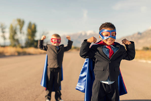dwóch chłopców ubrane w kostiumy i komplety superbohatera biznesowych - superhero child partnership teamwork zdjęcia i obrazy z banku zdjęć