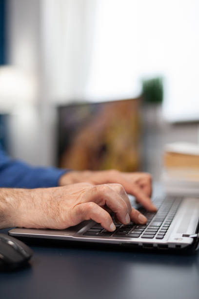 istock Close up of senior man hands typing 1865653774