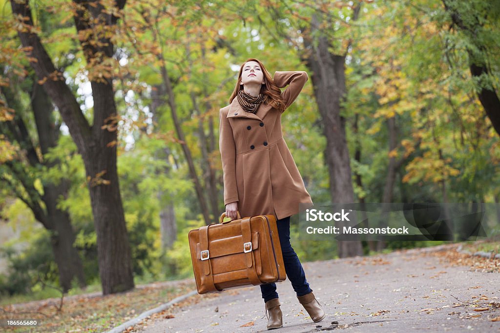 Redhead girl avec valise à l'automne en plein air - Photo de A la mode libre de droits