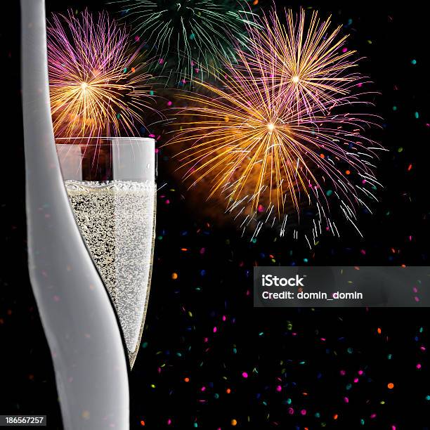 Closeup Of Glass And Bottle Of Champagne Confetti Fireworks Display Stock Photo - Download Image Now
