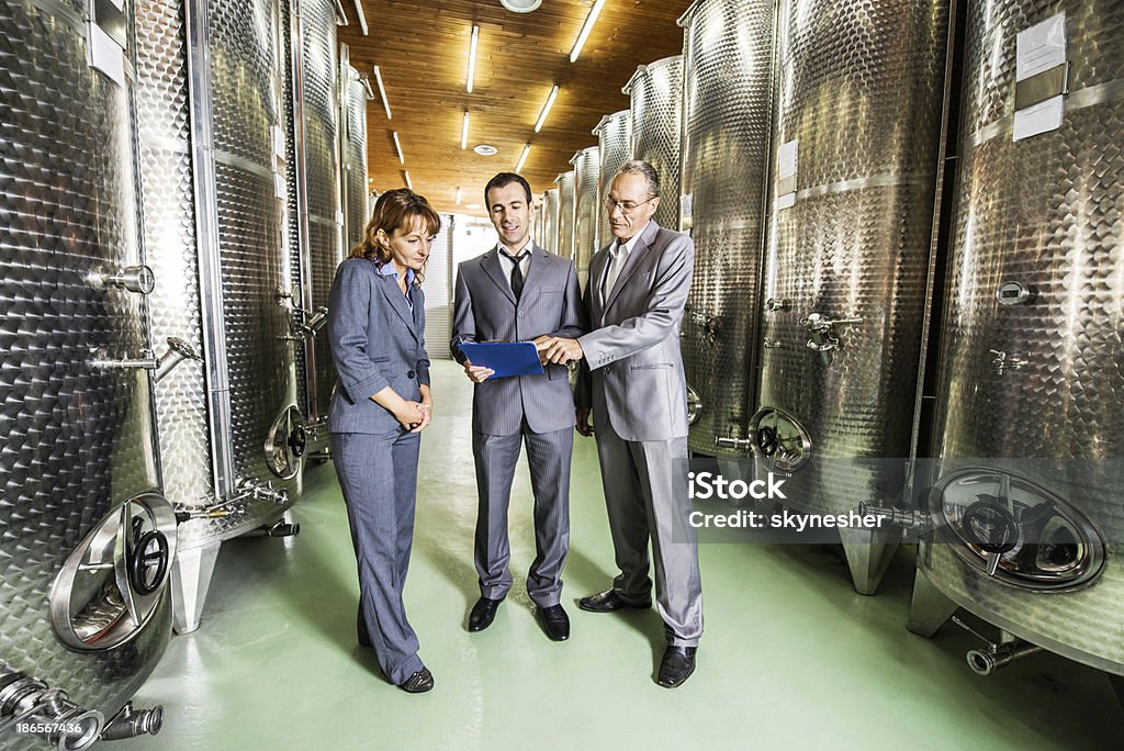 Uomini d'affari in una cantina di vini. - Foto stock royalty-free di Cantina