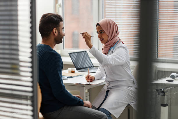 młoda lekarka w hidżabie bada wzrok pacjentki - penlight zdjęcia i obrazy z banku zdjęć