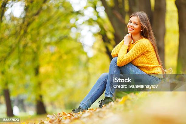 Frau Sitzt Auf Herbst Blätter Stockfoto und mehr Bilder von Attraktive Frau - Attraktive Frau, Blatt - Pflanzenbestandteile, Entspannung