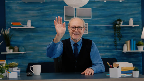 istock POV of elderly aged man waving during a video conference 1865681244