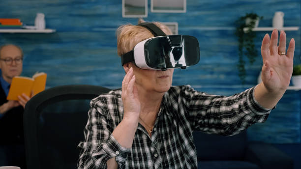 istock Retired concentrated senior woman using virtual reality goggles in living room 1865683345