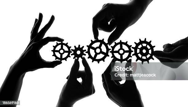 Silhouetted Hands Holding Mechanical Cogs And Gears Teamwork And Collaboration Concept Stock Illustration - Download Image Now