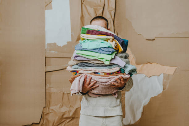 istock Unrecognizable man holding clothes over craft paper background 1865691693