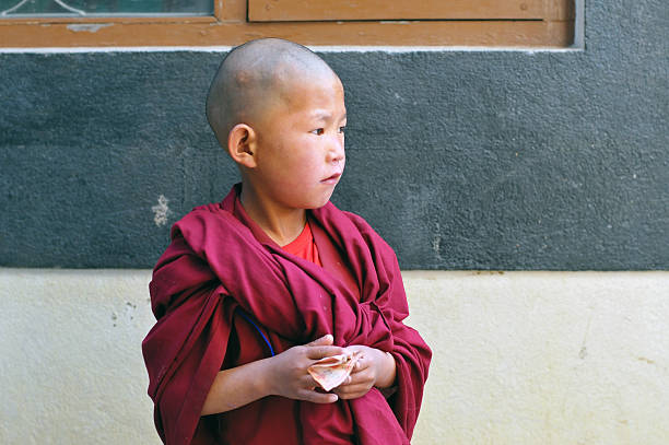 Little boudhist monk with money in his hands near bouddhist temple in Kathmandu, Nepal. Selective soft focus.