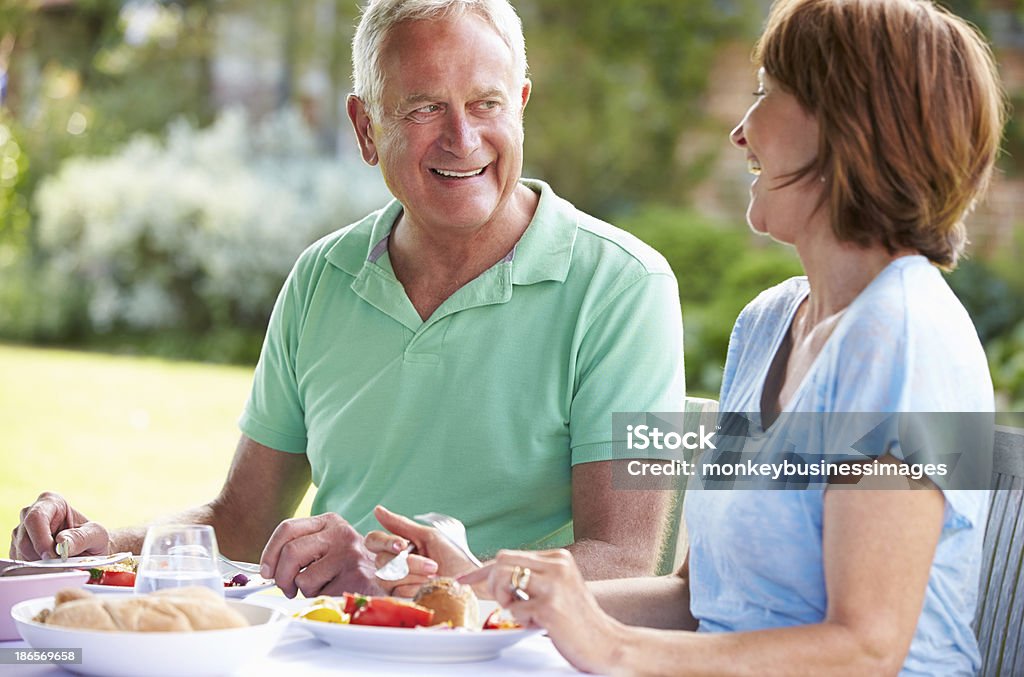 Starsza para cieszyć się posiłek na świeżym powietrzu razem - Zbiór zdjęć royalty-free (50-59 lat)