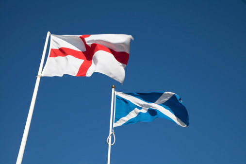 The National flag of England, the Cross of Saint George, flying alongside the national flag of Scotland, the Cross of Saint Andrew, or Saltire, on the border between the two countries.