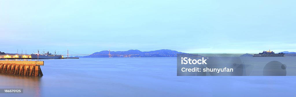 San Francisco: Alcatraz Island Golden Gate Bridge and Alcatraz Island of San Francisco just before sunrise.. Bay of Water Stock Photo