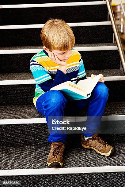 Total Atenção Menino Loiro Sentado Na Biblioteca Passos Leitura - Fotografias de stock e mais imagens de 10-11 Anos