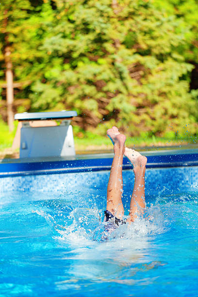 istock Children Jumping Off Diving Board in Summer Swimming Pool 186571170