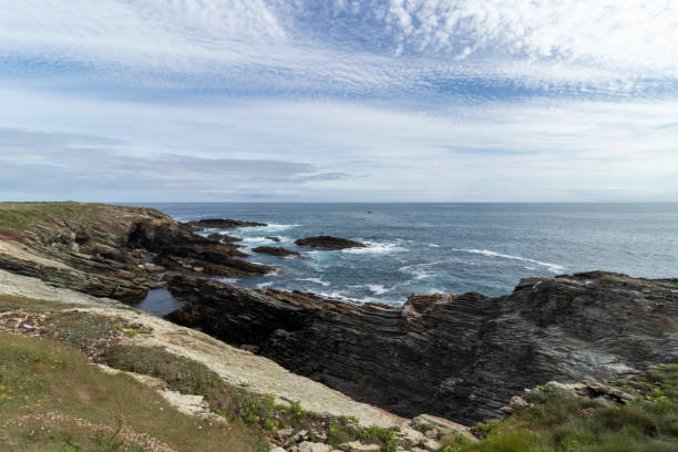 istock A scenic coastal landscape with rocky cliffs, turbulent sea, and a sky adorned with patterned clouds 1865722204