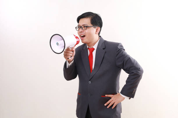 istock Angry asian businessman shouting using megaphone. Isolated on white 1865732102