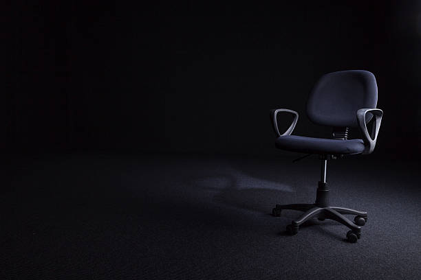 istock Used Office Chair On A Dark Carpet 186574748