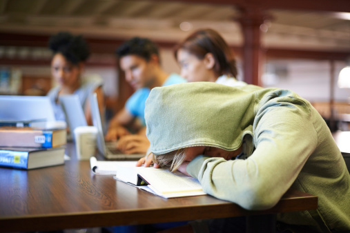 A young student in a study group suffering from the exhaustion of finals