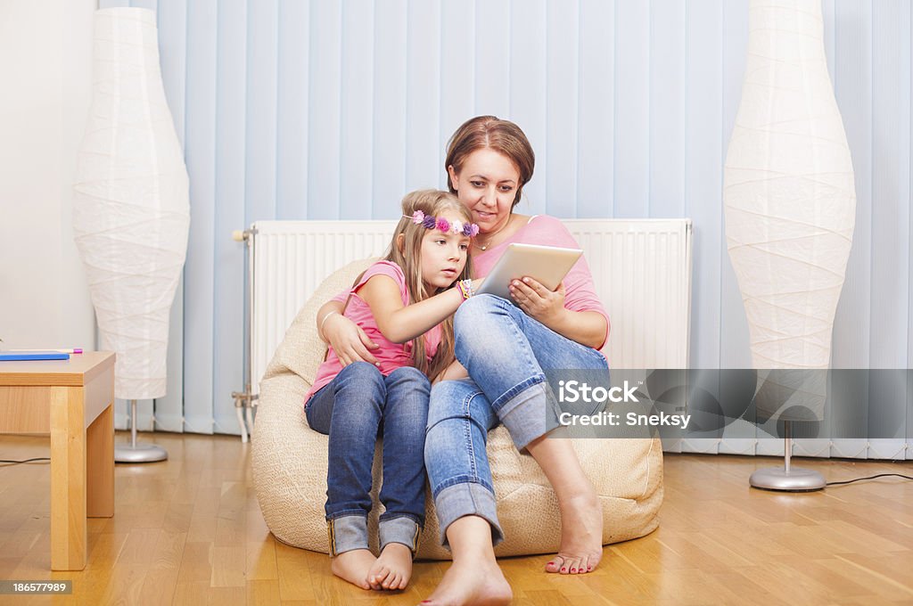 Mãe e filha se divertindo com o bloco de notas - Foto de stock de Abraçar royalty-free