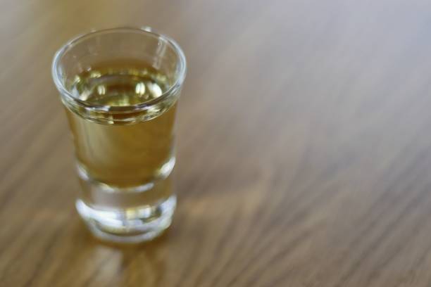 Shot of Rakija on a wooden table Rakia Serbian traditional drink shot glass serbian raki stock pictures, royalty-free photos & images