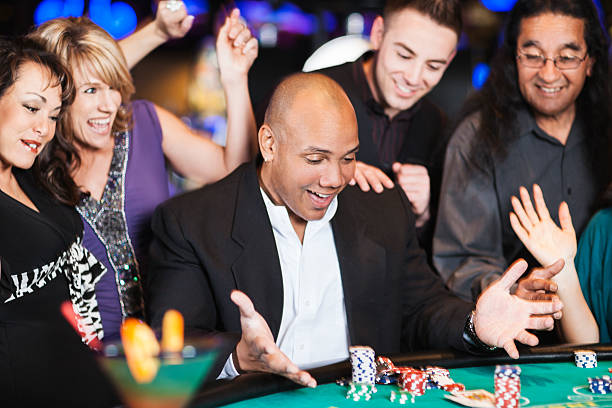 istock Excited winner at the blackjack table surrounded by happy friends 186579139
