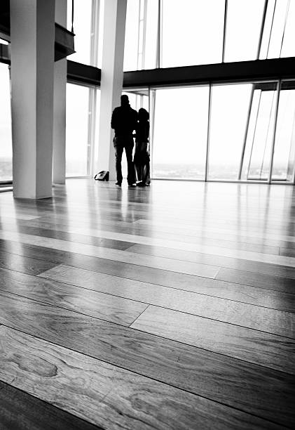 coppia guardando attraverso window.black e bianco - office indoors contemporary office building foto e immagini stock
